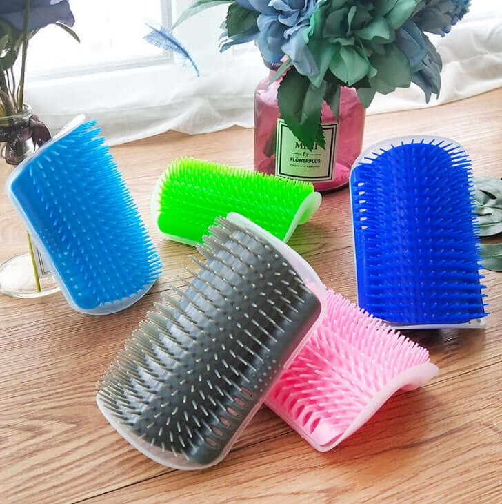 Colorful cat self-grooming brushes in various shades on a wooden surface, designed for gentle pet massage and combing.