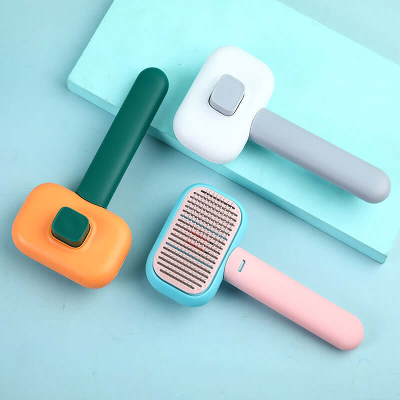 Open-Knot Brush Grooming, three colorful comb brushes in smoke grey, blue pink, orange green on a blue surface.