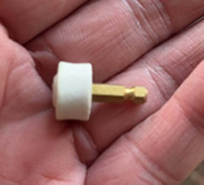 Close-up of a small pet nail grinder attachment on a hand, showcasing its compact design for easy pet grooming.